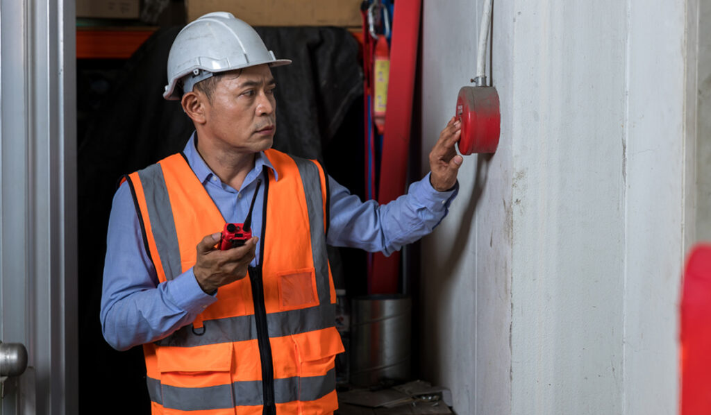 Foreman pushing fire alarm